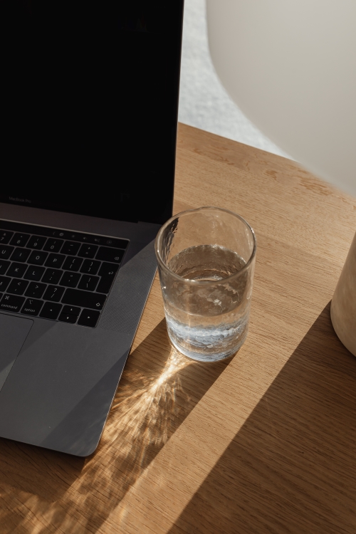 laptop on a table with glass of water